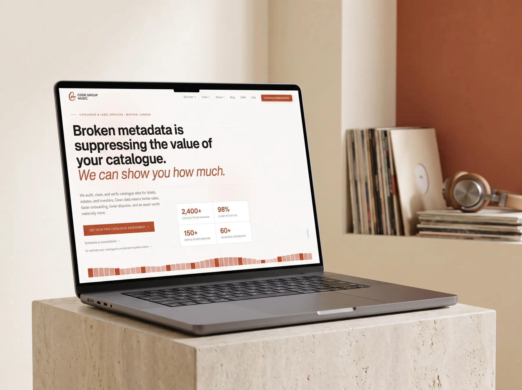 Code Group Music website on a MacBook Pro on a stone plinth beside vinyl records